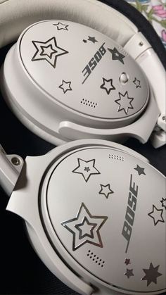 two white headphones with designs on them