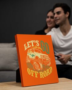 a man and woman sitting on a couch next to each other with a sign that says let's go off road