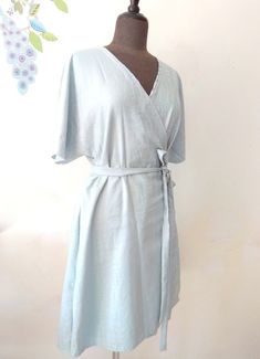 "Easy kimono sleeve summer wrap dress. Above knee or knee length. Versatile piece. Great for office wear or to a wedding. Made to order in sizes: S, M, L, XL Size S to fit bust 32-34\", waist 25-27\" and hips 35-37\" Size M to fit bust 36-38\", waist 29-31\" and hips 38-41\" Size L to fit bust 40-42\", waist 33-35\" and hips 42-44\" Size XL to fit bust 44-46\", waist 37-39\" and hips 45-47\" Available in Cotton or Linen. Blue dress on Mannequin is sold out" Summer A-line Belted Wrap Dress, Summer Wrap Dress With Kimono Sleeves And Belted Waist, Summer Wrap Dress With Kimono Sleeves And Belt, Fitted Dresses With Kimono Sleeves For Summer, Fitted Summer Wrap Dress With Kimono Sleeves, Fitted Wrap Dress With Kimono Sleeves For Summer, Blue Wrap Dress For Beach, Fitted Belted Dress With Kimono Sleeves, Belted Fitted Dress With Kimono Sleeves