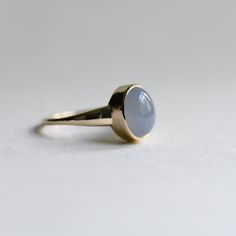 Simple blue Chalcedony stone set on 14k yellow gold. Metal: 14K yellow gold Stone: Blue Chalcedony Stone Shape: Oval Stone Size: 8mm x 10mm 1.4mm band width. Blue Cabochon Sapphire Ring In 14k Gold, Oval Blue Opal Ring In 14k Gold, Classic Blue Opal Round Ring, Classic Blue Domed Jewelry, Blue Oval Moonstone Ring In 14k Gold, 14k Gold Blue Cabochon Rings, Blue Cabochon 14k Gold Ring, Classic Oval Blue Moonstone Ring, Blue Opal Ring In 14k Gold For Formal Occasions