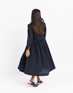 Vintage-inspired black semi-formal dress with delicate gathers around the waist. Relax-fitted long sleeves and overlapping neckline add to the charm. Handcrafted from organic cotton fabric, this modern dress carries a nostalgic sensibility. Fitted empire waistline elegantly showcases your curves. Overlapping Neckline, Fit And Flare Midi Dress, Flare Midi Dress, Classic Black Dress, Semi Formal Dress, Empire Waistline, Organic Cotton Fabric, Mid Dresses, Versatile Dresses