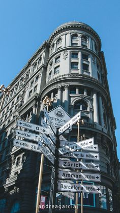 a street sign in front of a building with many different signs on it's sides