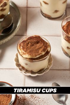 three desserts are sitting on the table with spoons next to them and one is topped with whipped cream