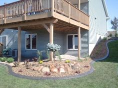 a house with a deck and landscaping in the front yard