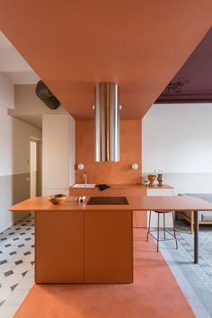 a kitchen with an orange counter top next to a dining room table