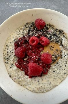 a bowl filled with oatmeal and raspberries on top of it