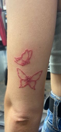 a woman's leg with a tattoo on it that has a bow in the shape of a heart