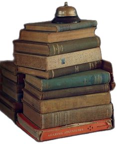 a stack of books sitting on top of each other next to a bell shaped object