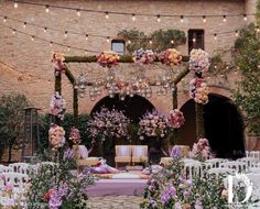 an outdoor ceremony with flowers and lights