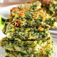 three pieces of broccoli are stacked on top of each other in front of a plate