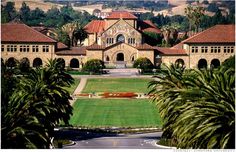 an image of a large building with trees in the foreground and mountains in the background