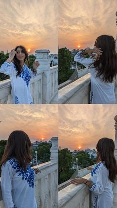 a woman standing on top of a bridge next to the sun in her hair and wearing a white shirt