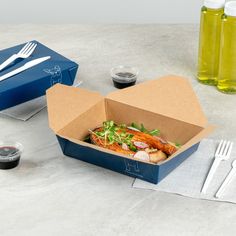 an open take out box on a table with utensils