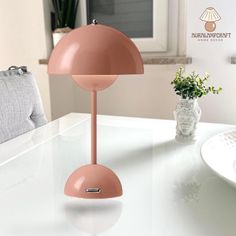 a pink lamp sitting on top of a white table