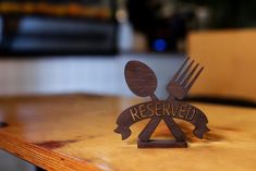 a wooden sign that says reserved with a fork and knife stuck in the middle of it