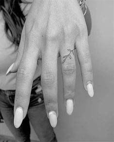 a woman's hand with a small tattoo on it