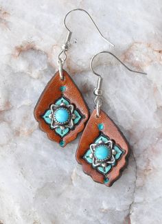 These petite earrings have vintage turquoise and sterling silver pieces mounted on a leather earring.  The turquoise and sterling pieces were originally clip on earrings I found at an estate sale - I mounted them to the leather, then accented them with stamping, dye and paint.    1 7/8" long including the ear wire, 3/4" wide. Handmade Blue Leather Earrings, Rustic Hand Tooled Leather Jewelry, Turquoise Concho Dangle Jewelry, Brown Southwestern Jewelry With Patina, Southwestern Brown Jewelry With Patina, Brown Southwestern Teardrop Jewelry, Southwestern Brown Teardrop Jewelry, Southwestern Style Teardrop Brown Jewelry, Southwestern Style Brown Teardrop Jewelry