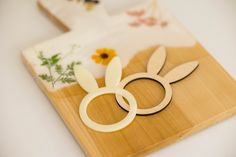 a wooden cutting board topped with paper cut outs and bunny ears on top of it