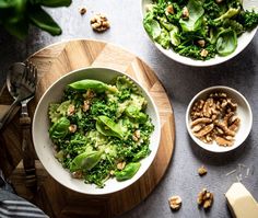 two bowls filled with green vegetables and nuts