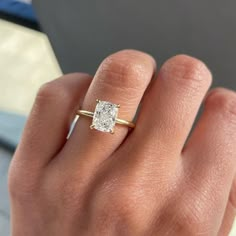 a woman's hand with a diamond ring on it