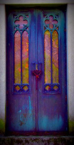 an old blue door with stained glass on it