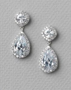 two pairs of earrings with cubicles and diamonds on the bottom, one in white gold