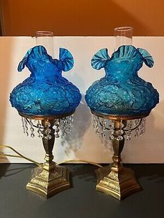 two blue vases sitting on top of a table