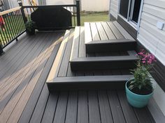 a potted plant sitting on top of a wooden deck next to steps and railing