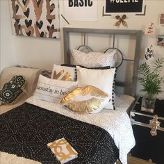 a bed room with a neatly made bed and pictures on the wall above it's headboard