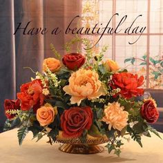 a vase filled with lots of different colored flowers on top of a table next to a window