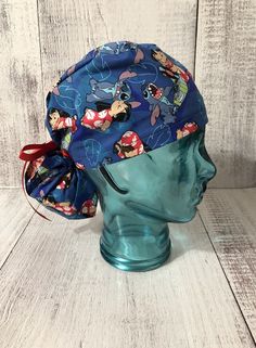 a blue scrub hat with cartoon characters on it, sitting on top of a mannequin head