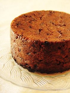 a chocolate cake on a glass plate sitting on a table