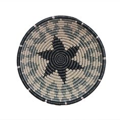 a black and white woven basket with an intricate design in the center on a white background