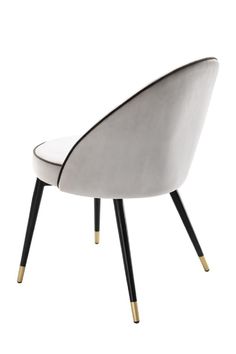 a white and black chair with gold legs