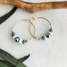 These unique and elegant 18k gold plated hoops are strung with a mix of fire polished Beads, Toho seed glass beads in sea green, real shell beads with a touch of gold and 3mm gold filled beads. They are then finished with tiny Miyuki Japanese seed beads. Easy to wear and would be great for summer and holiday wardrobes! All items come carefully packaged ready for gifting in sparkly tissue paper and a small jute bag with seaside charm. A white logo'd gift box is available for a small additional co Bohemian Beaded 14k Gold Filled Earrings, Bohemian 14k Gold Filled Beaded Earrings, Bohemian 14k Gold-filled Beaded Earrings, Bohemian 14k Gold Filled Round Beaded Earrings, Gold Beaded Hoop Earrings For The Beach, Gold Hoop Earrings With Tiny Beads For Summer, Bohemian 14k Gold Filled Earrings With Tiny Beads, Gold Hoop Earrings With Colorful Beads For Beach, Bohemian 14k Gold Filled Jewelry For Beach