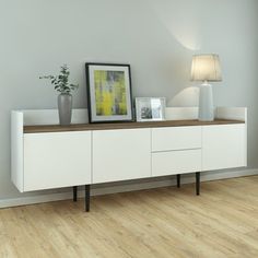 a white cabinet with two vases on top and a framed photograph next to it