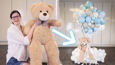 a woman holding a large teddy bear next to balloons