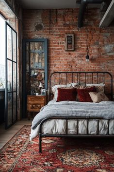 a bedroom with brick walls and an antique rug on the floor, along with a metal bed frame