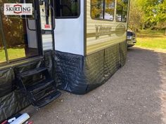 an rv parked on the side of a road with its door open and tarp over it