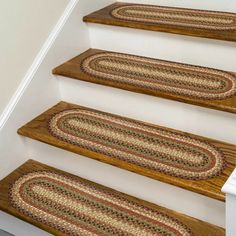 the stair treads are made from wood and have braided rugs on them