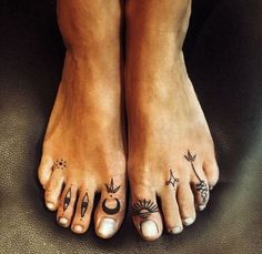 two feet with different tattoos on them and one has the sun, moon and stars