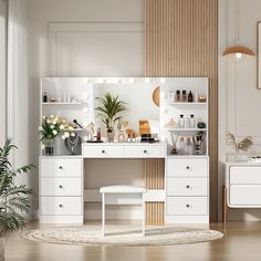 a room with white furniture and plants in the corner, including a dressing table and mirror