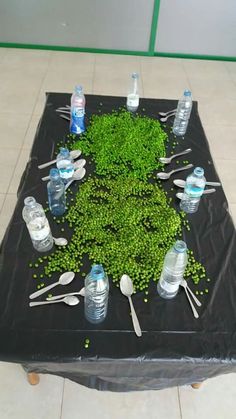 a table topped with lots of water bottles and utensils on top of a tiled floor