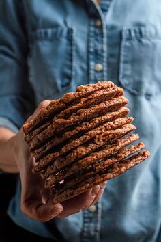 a person holding a stack of cookies in their hand