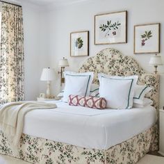 a bed with white sheets and pillows in a bedroom next to two lamps on either side of the bed