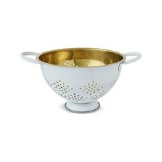 a white and gold colander on a white background