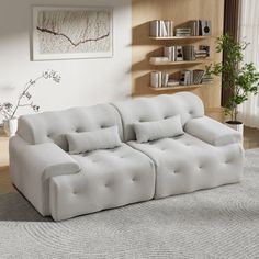 a white couch sitting on top of a rug in a living room