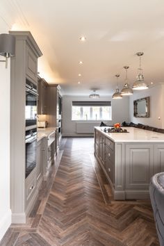 a large kitchen with an island, oven and dining room table in the middle of it