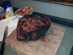 a steak on a cutting board next to a knife and some other food in a bowl