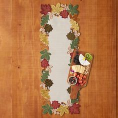 a wooden table topped with a plate of fruit and veggies next to a paper banner